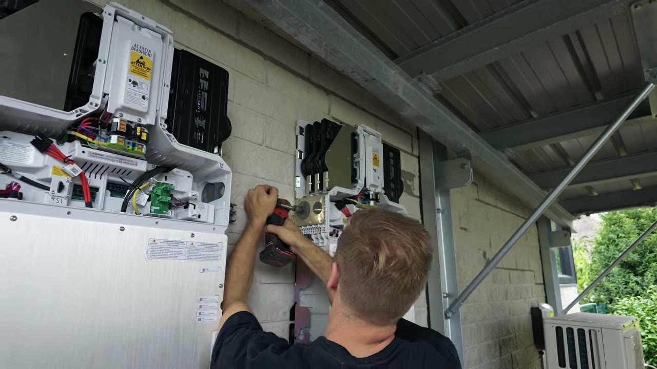 Monteur sluit een geopende Enphase-batterij aan